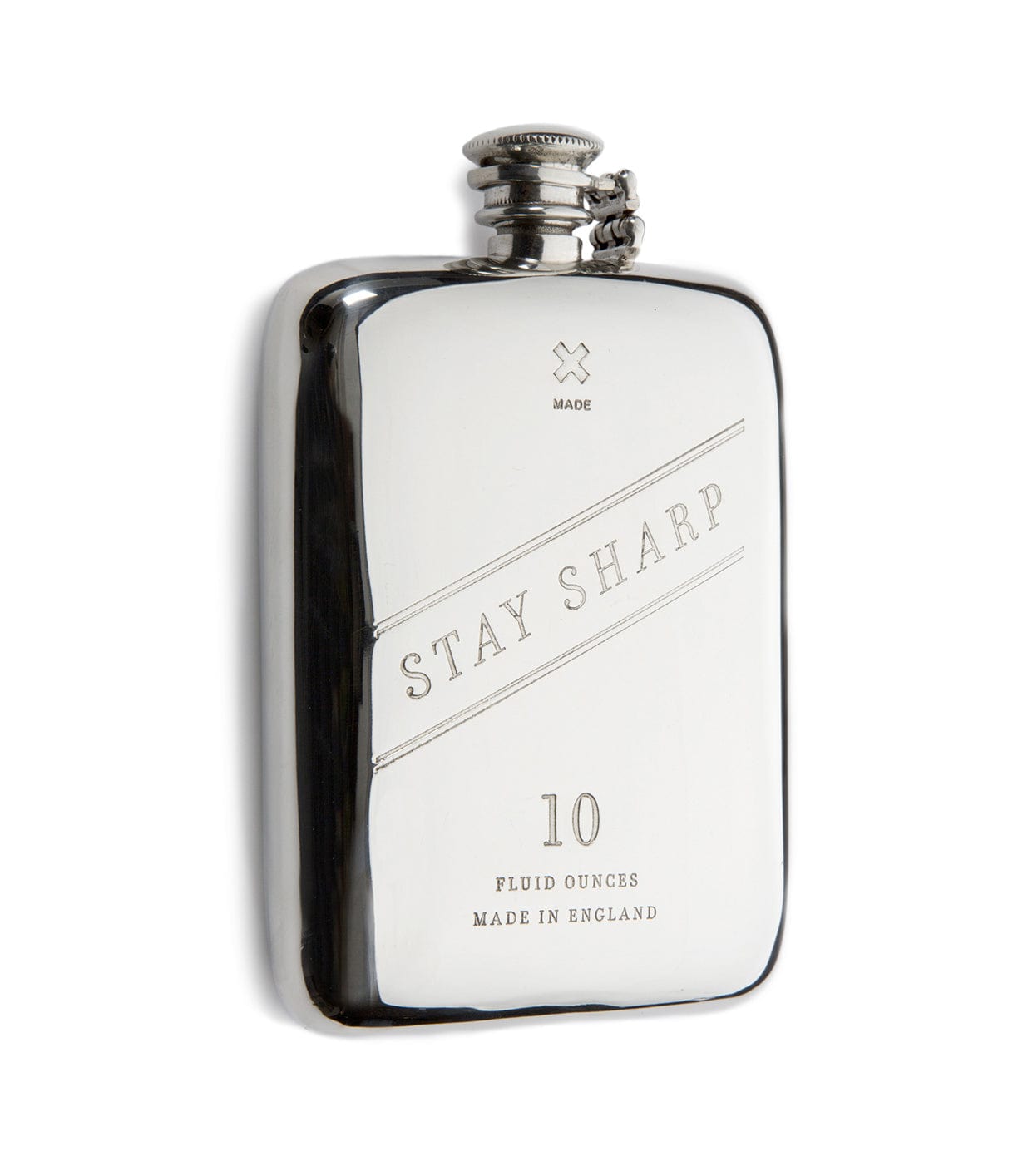 A shiny silver hip flask with the words STAY SHARP engraved on the front. It holds 10 fluid ounces and has MADE IN ENGLAND etched at the bottom.