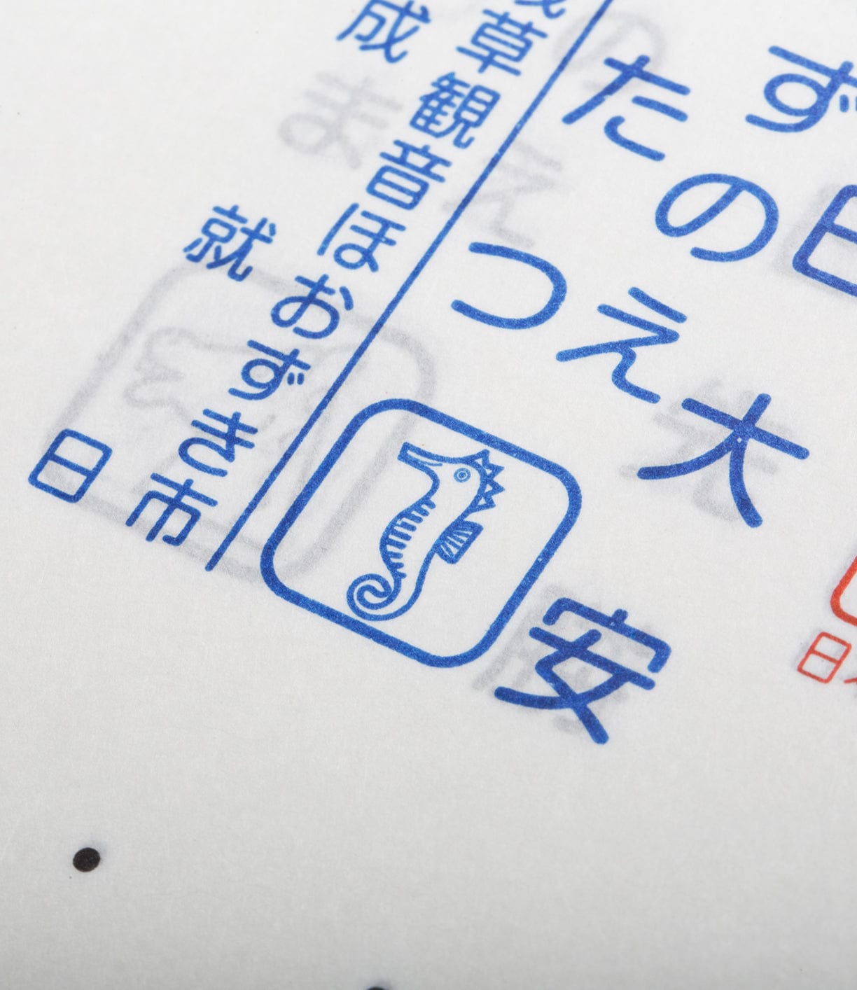 Close-up image of blue Japanese text and symbols on a white background, featuring a seahorse icon in a square.