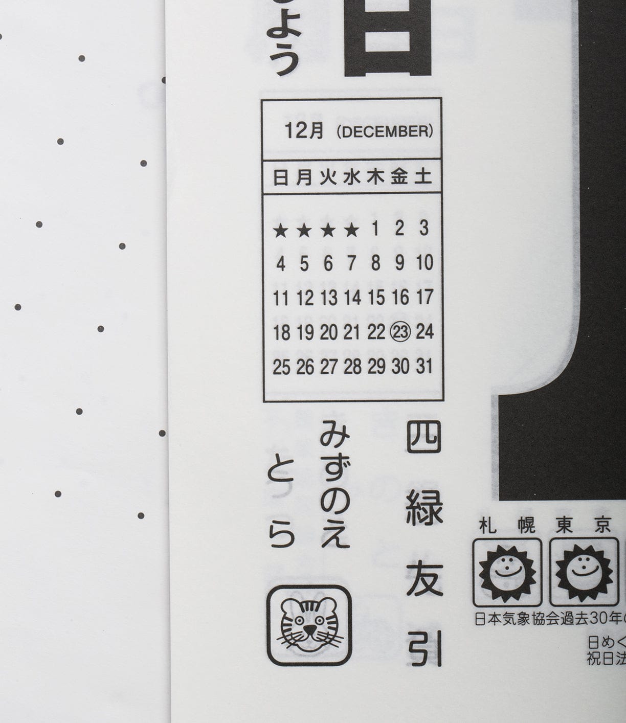 A close-up of a Japanese calendar highlighting the month of December. The 24th is circled. The calendar also features black and white illustrations and Japanese text.