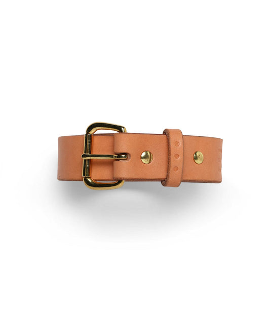 A tan leather belt with a brass buckle and rivet detailing is displayed against a white background.