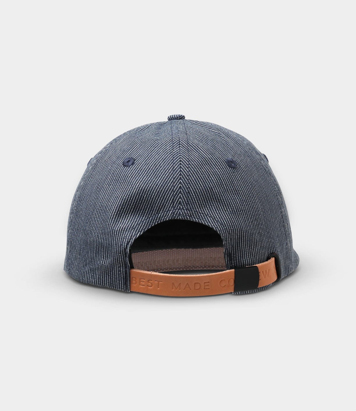 A denim baseball cap is shown from the back, featuring a leather strap with the words BEST MADE CO embossed on it.