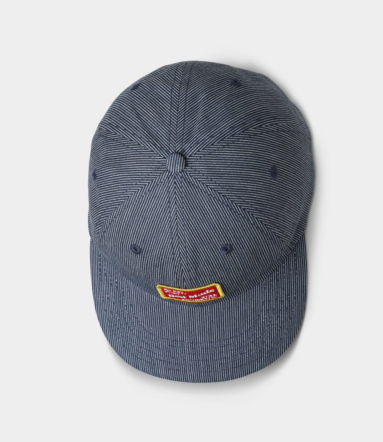 A blue baseball cap with a yellow and red logo patch on the front, displaying small white text.