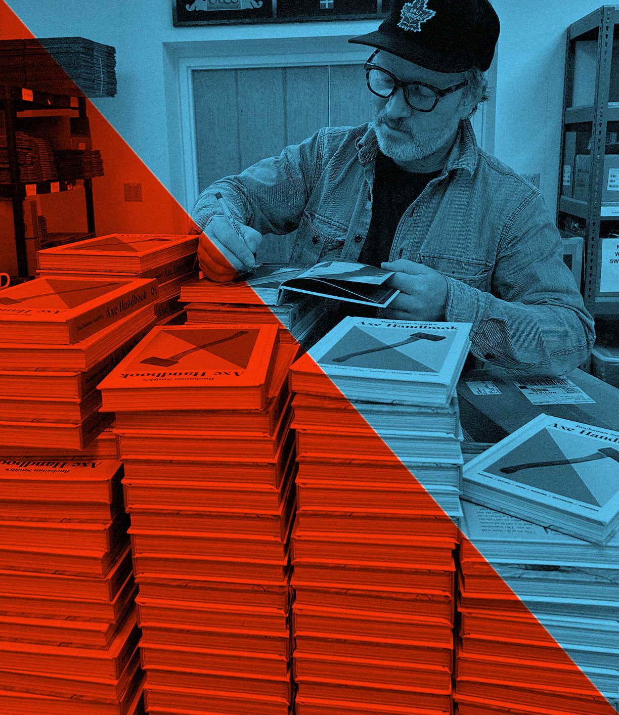 A person wearing a cap and denim jacket is signing copies of books at a table with tall stacks of the same book. The photo has a red and blue filter effect.