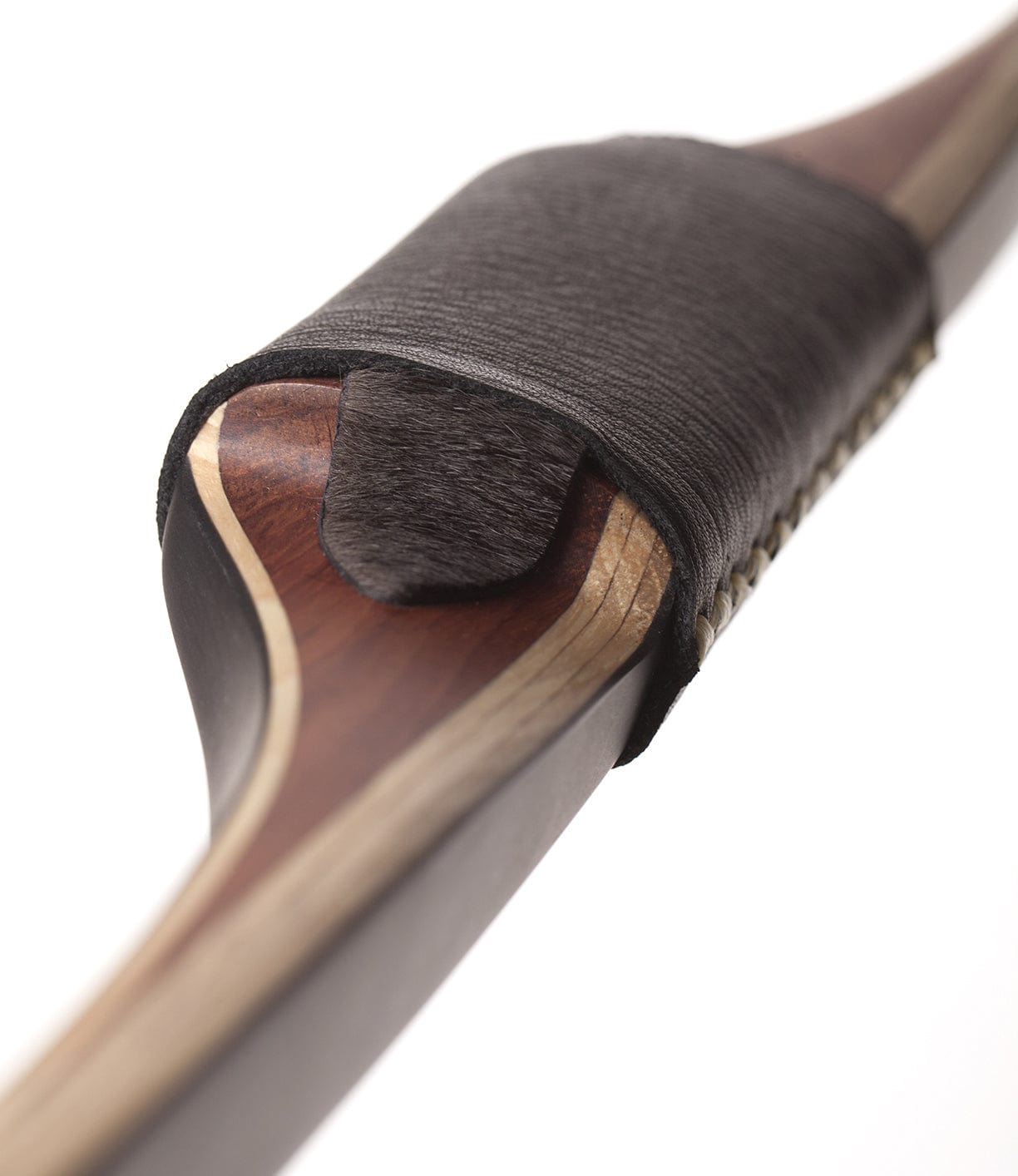 Close-up image of the grip section of a traditional wooden recurve bow, showing detailed craftsmanship, including a leather wrap and decorative stitching.