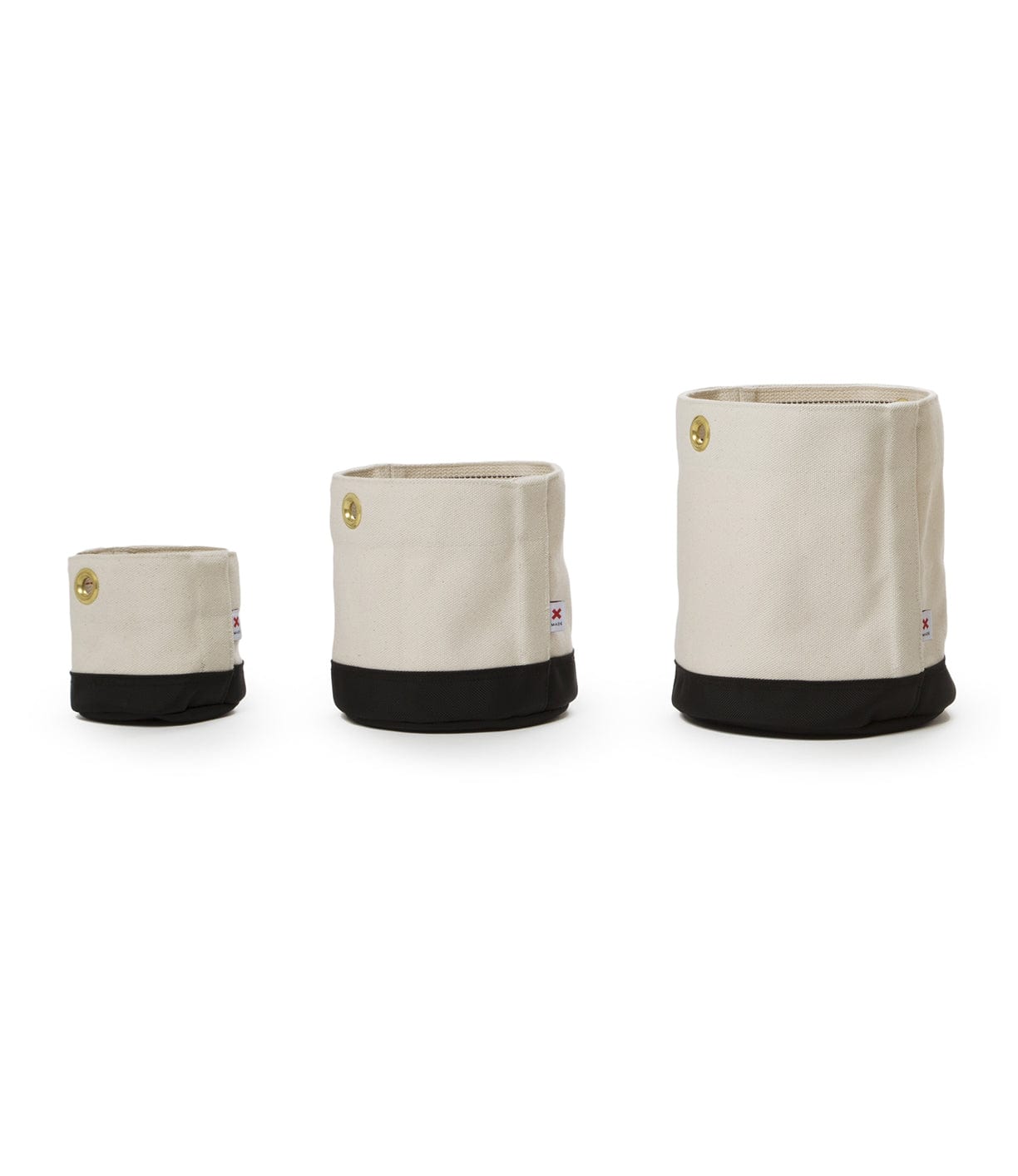 Three fabric storage bins of varying sizes, each with a beige top and black bottom, arranged in a row from smallest to largest.