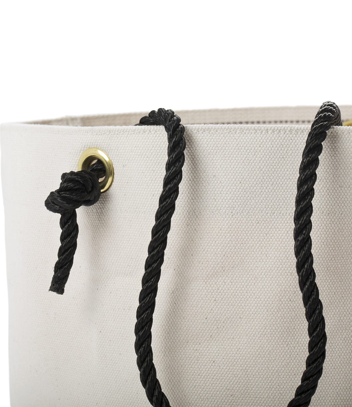 Close-up of a beige fabric bag with a black rope handle threaded through a metal grommet.