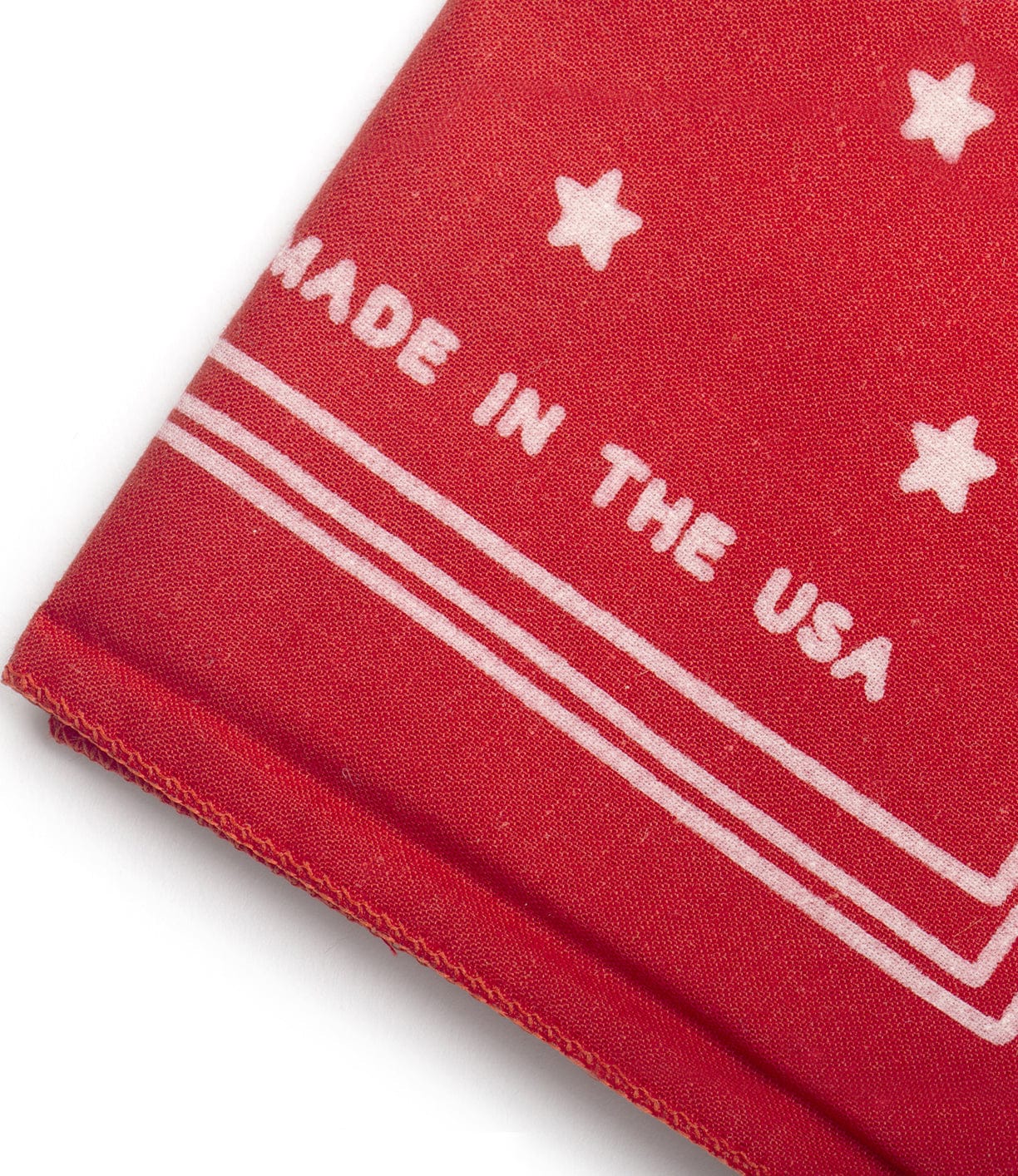 Close-up of a red fabric with white stars and the text MADE IN THE USA printed on it.