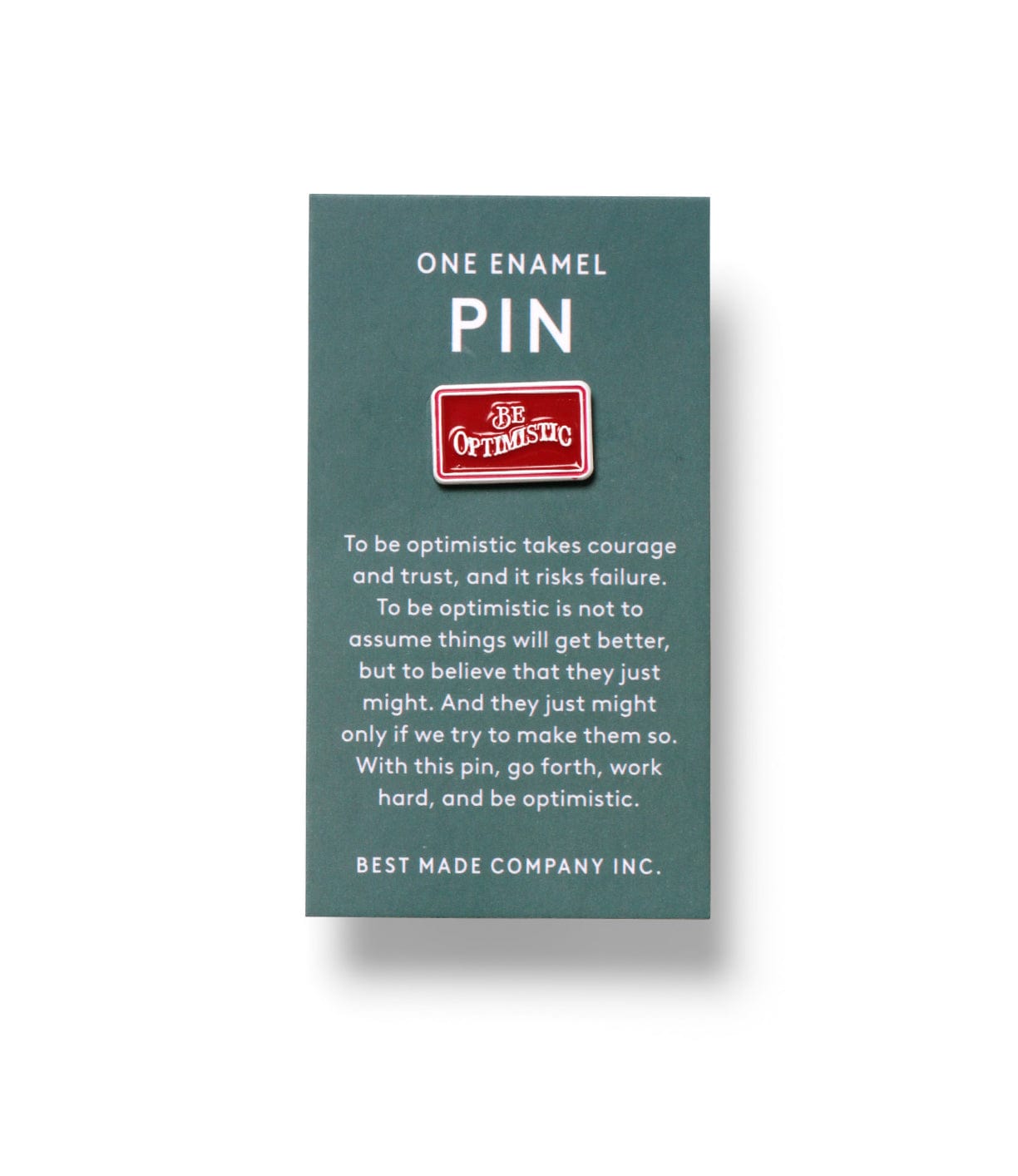 A green card displaying a small red enamel pin with the words Be Optimistic. Text beneath explains the importance of courage and hard work in maintaining optimism. BEST MADE COMPANY INC. is printed below.