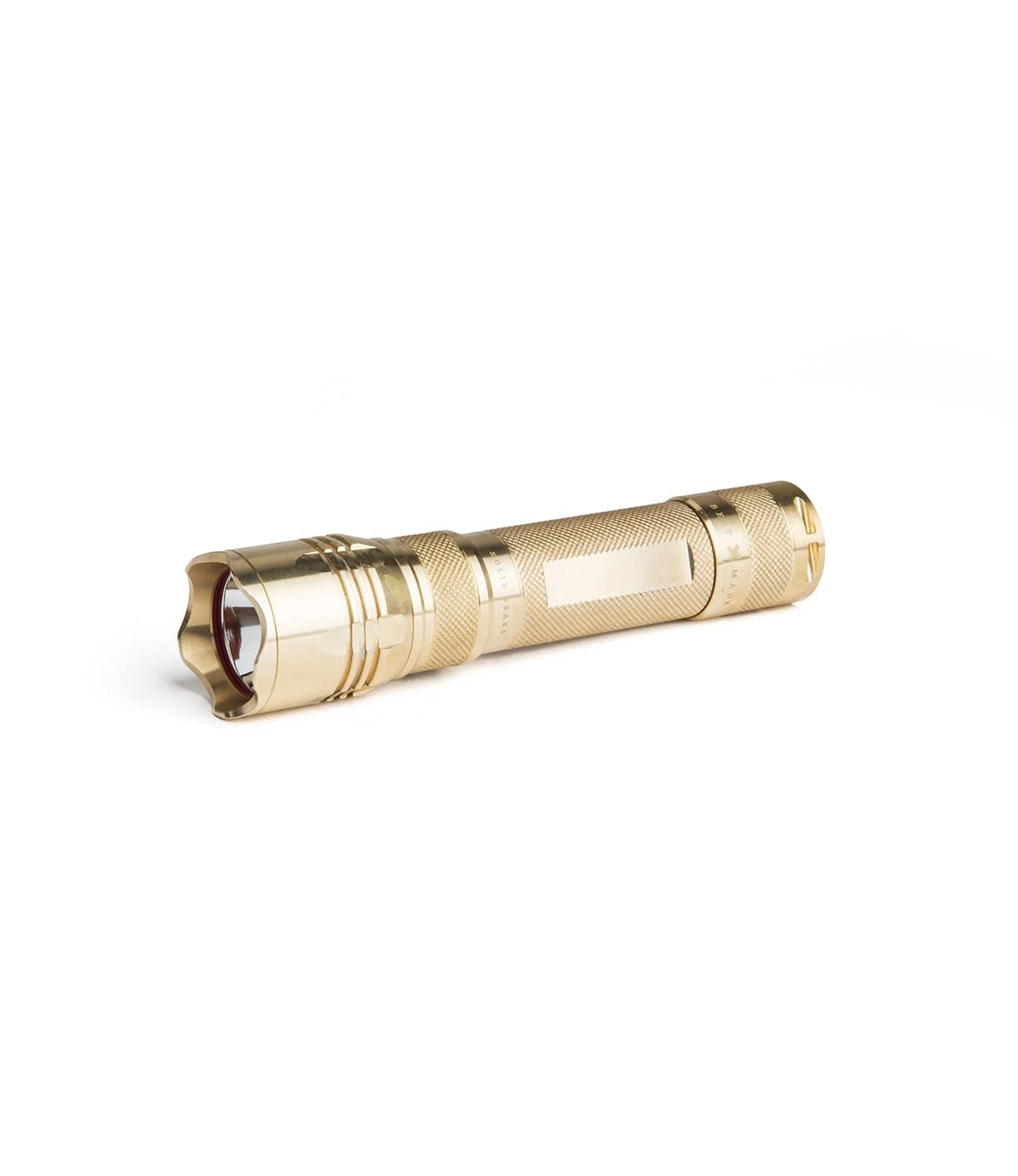 Gold-colored flashlight with a textured grip and a beveled front edge lies horizontally on a white background.