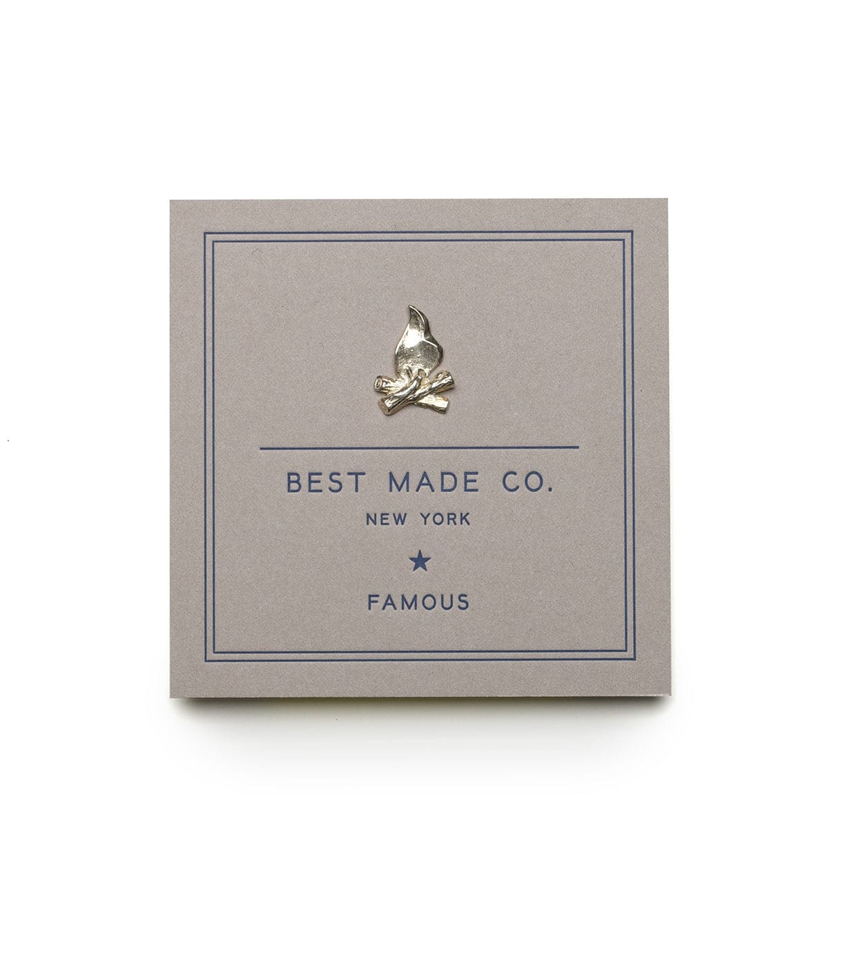 A grey card with Best Made Co. New York Famous printed in blue, featuring a pin of a campfire with crossed logs.