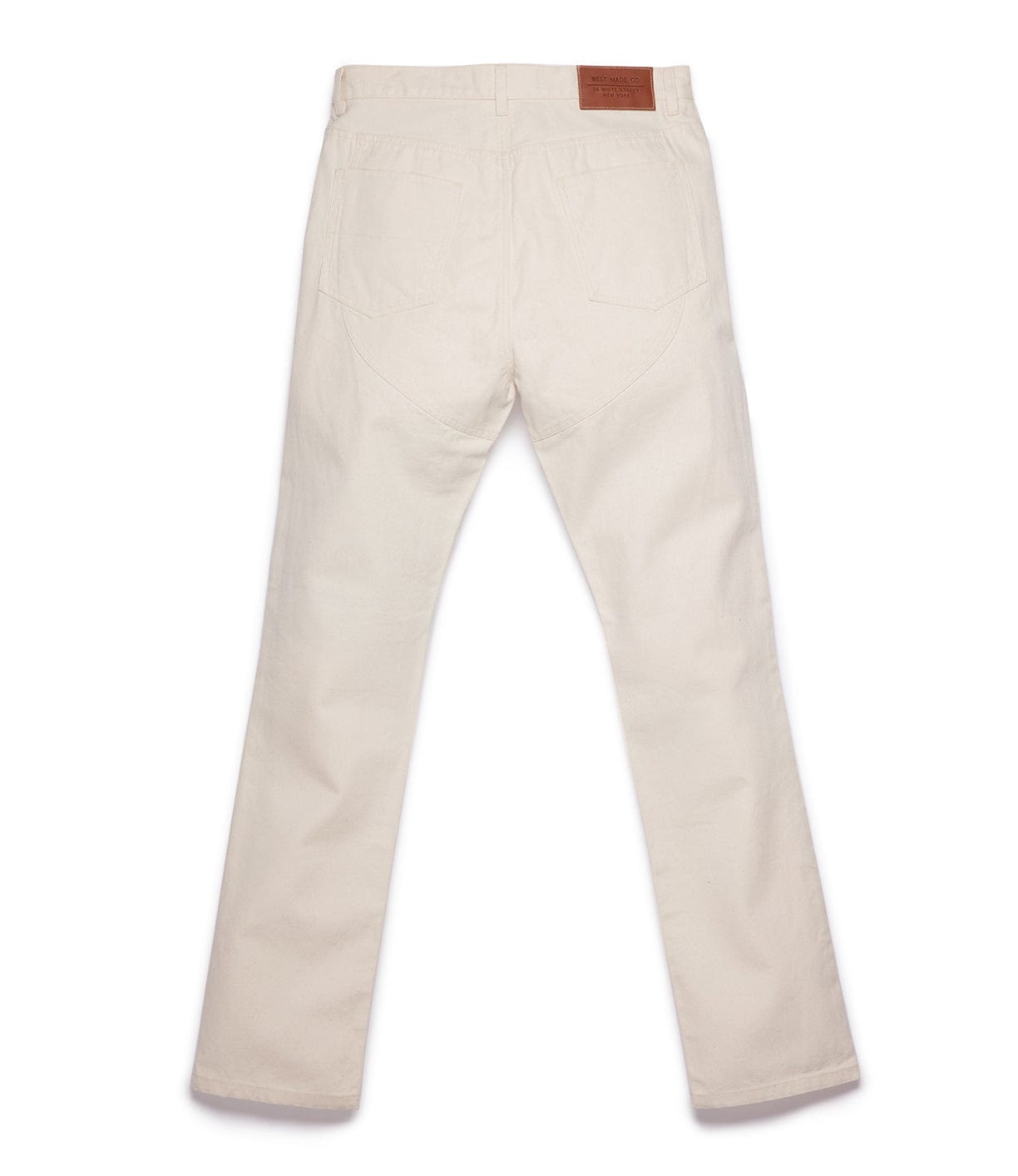 A pair of off-white jeans viewed from the back, featuring a straight leg cut and a brown leather patch on the waistband.