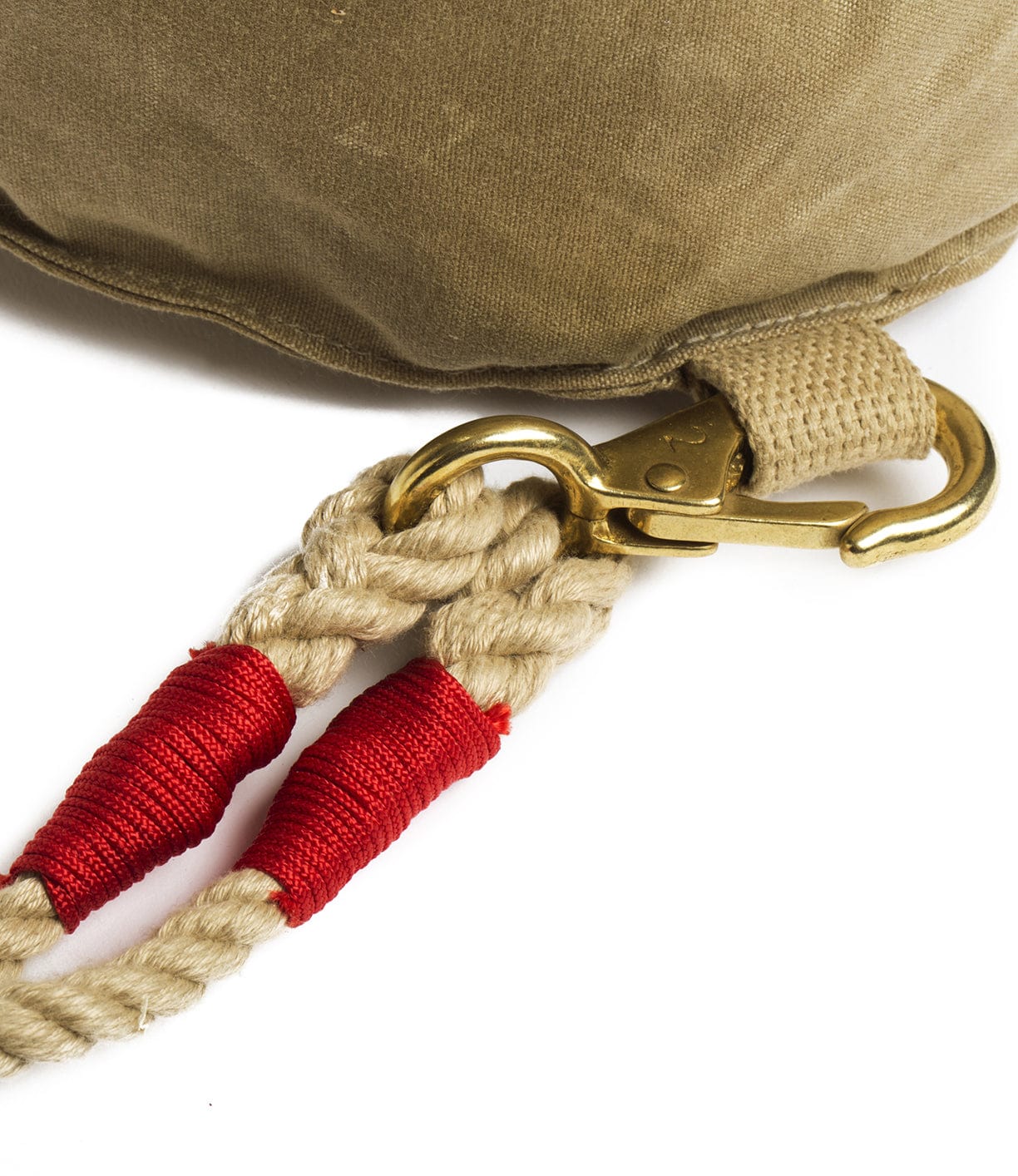 Close-up of a beige canvas bag with a metal clip attached to two beige ropes secured with red bindings. The clip and ropes are designed for secure fastening.