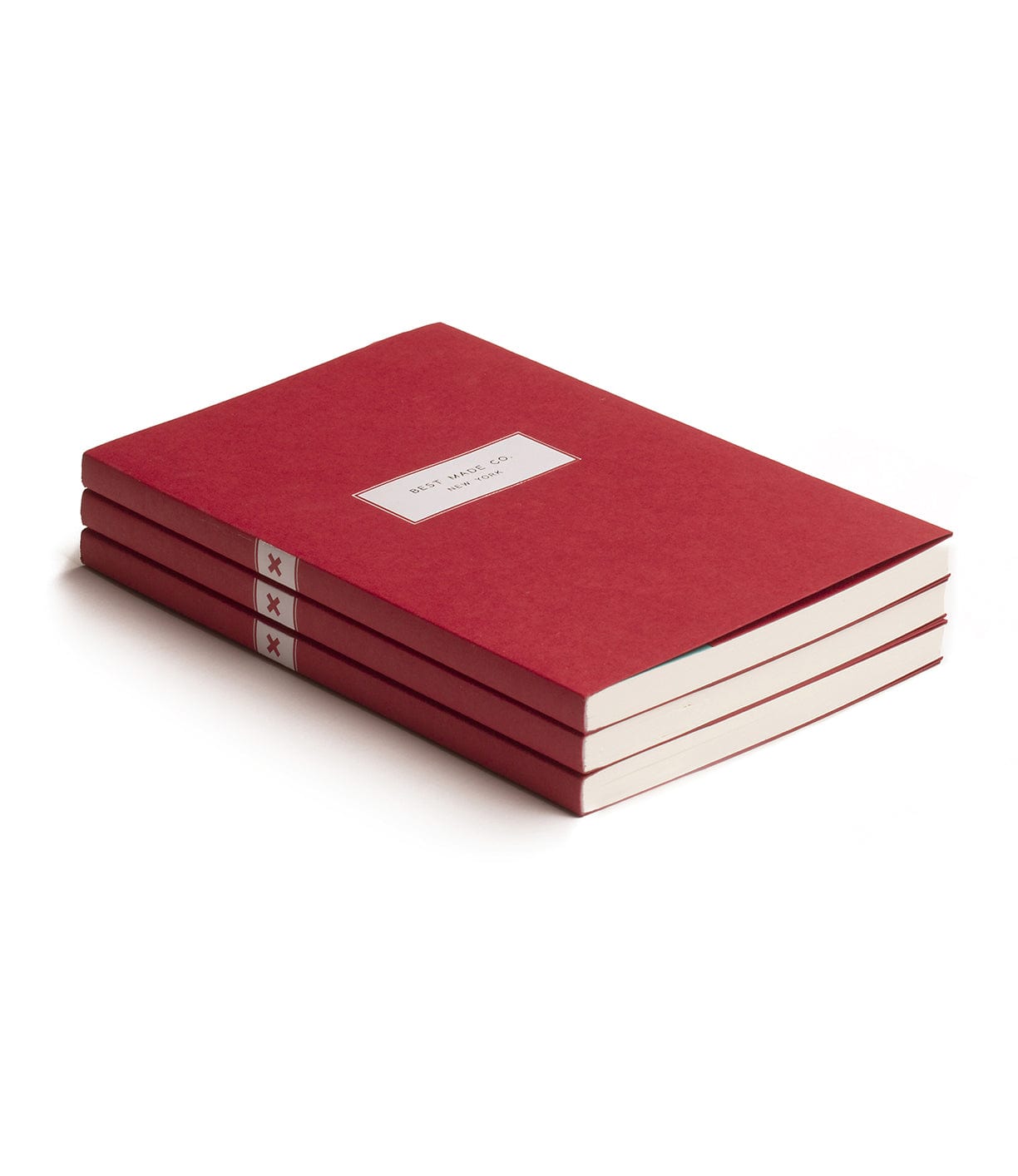 A stack of three closed, red, hardcover notebooks with white labels and white pages, placed on a white surface.