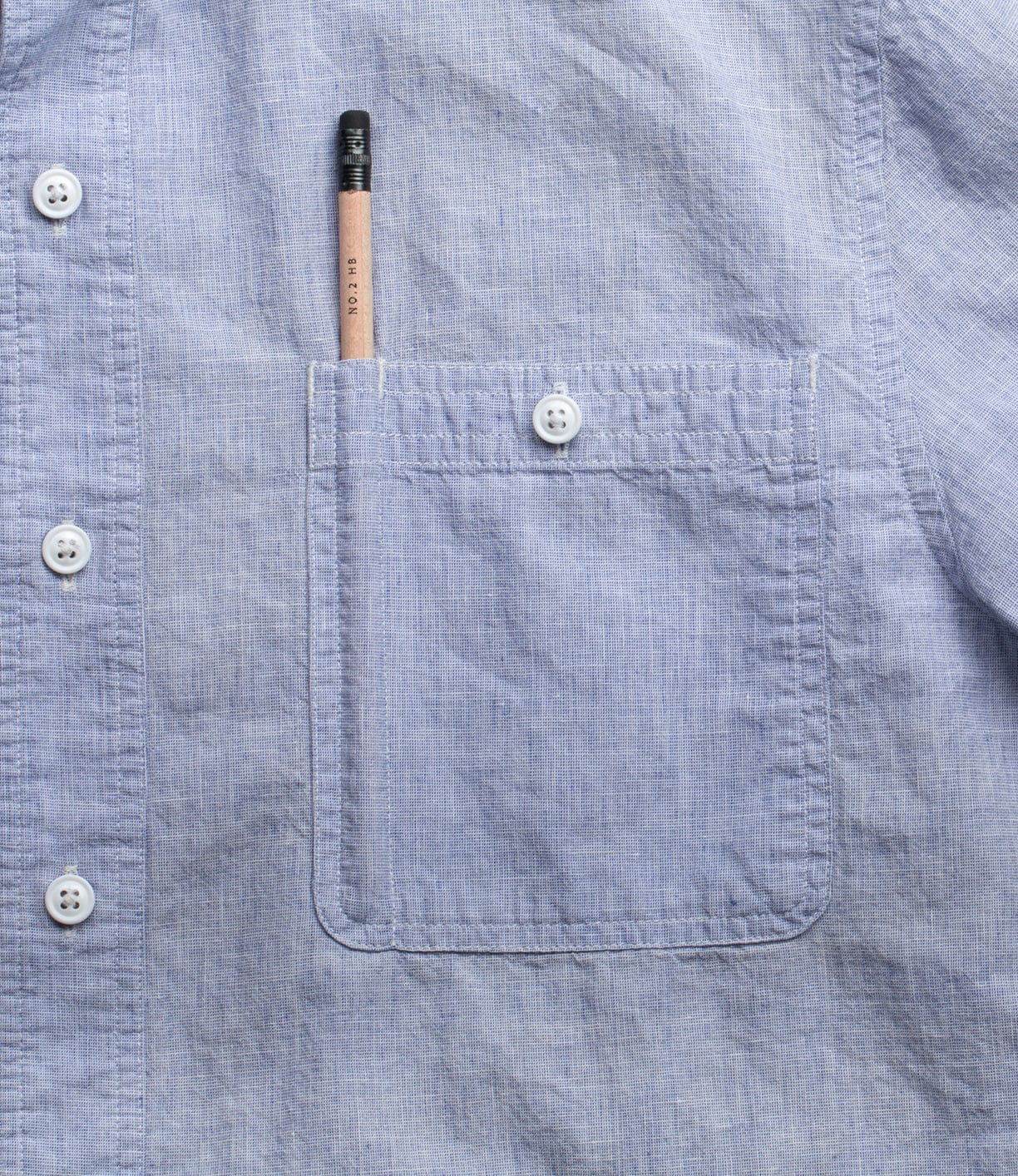 Light blue button-up shirt with a left chest pocket containing a pencil.