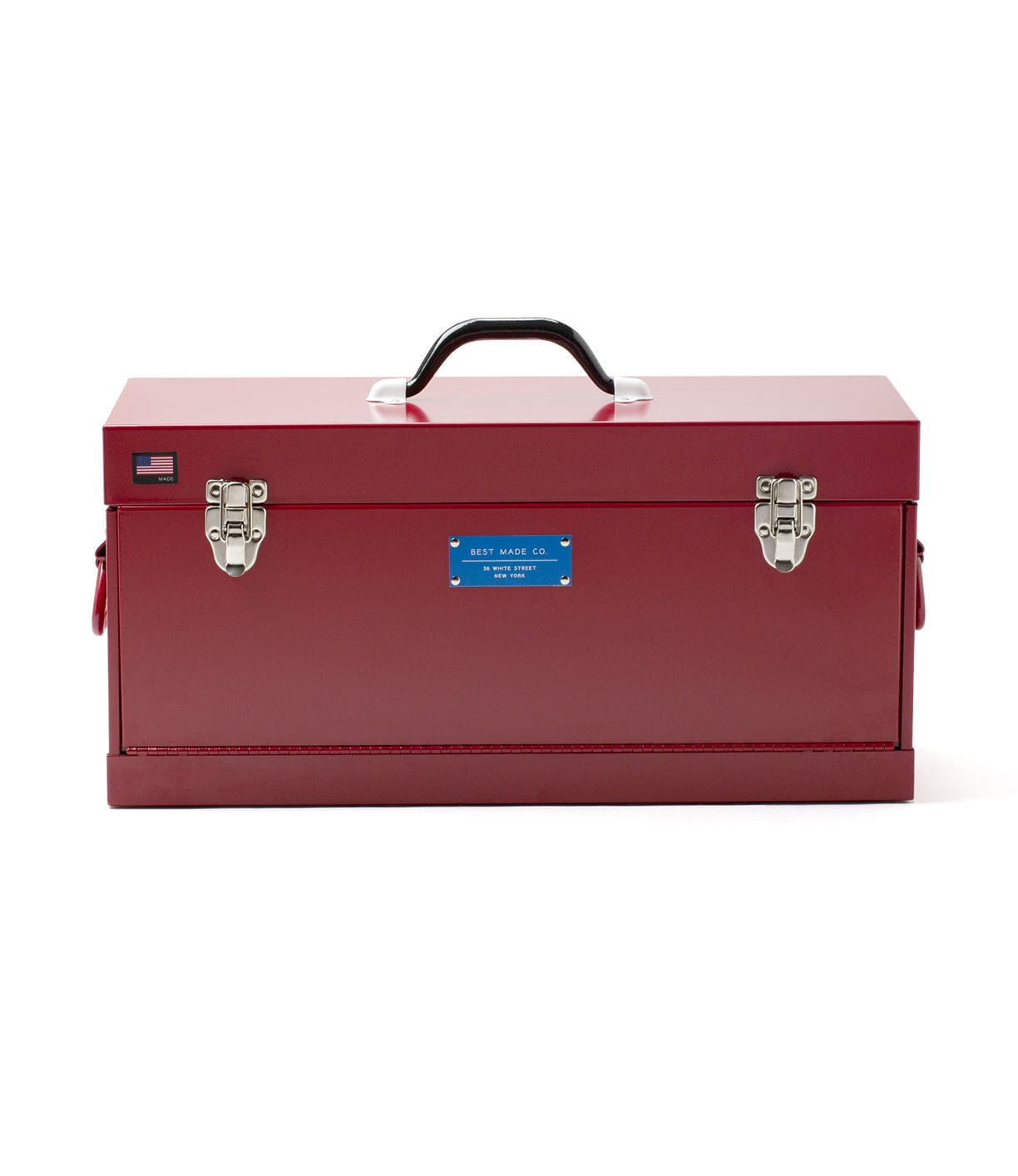 A red metal toolbox with a black handle, two silver latches, an American flag decal, and a blue label on the front.