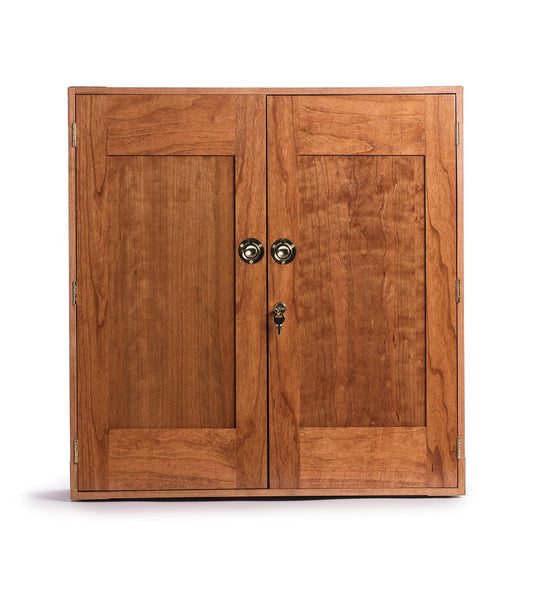 A wooden cabinet with two doors, featuring brass knobs and a keyhole on one door.