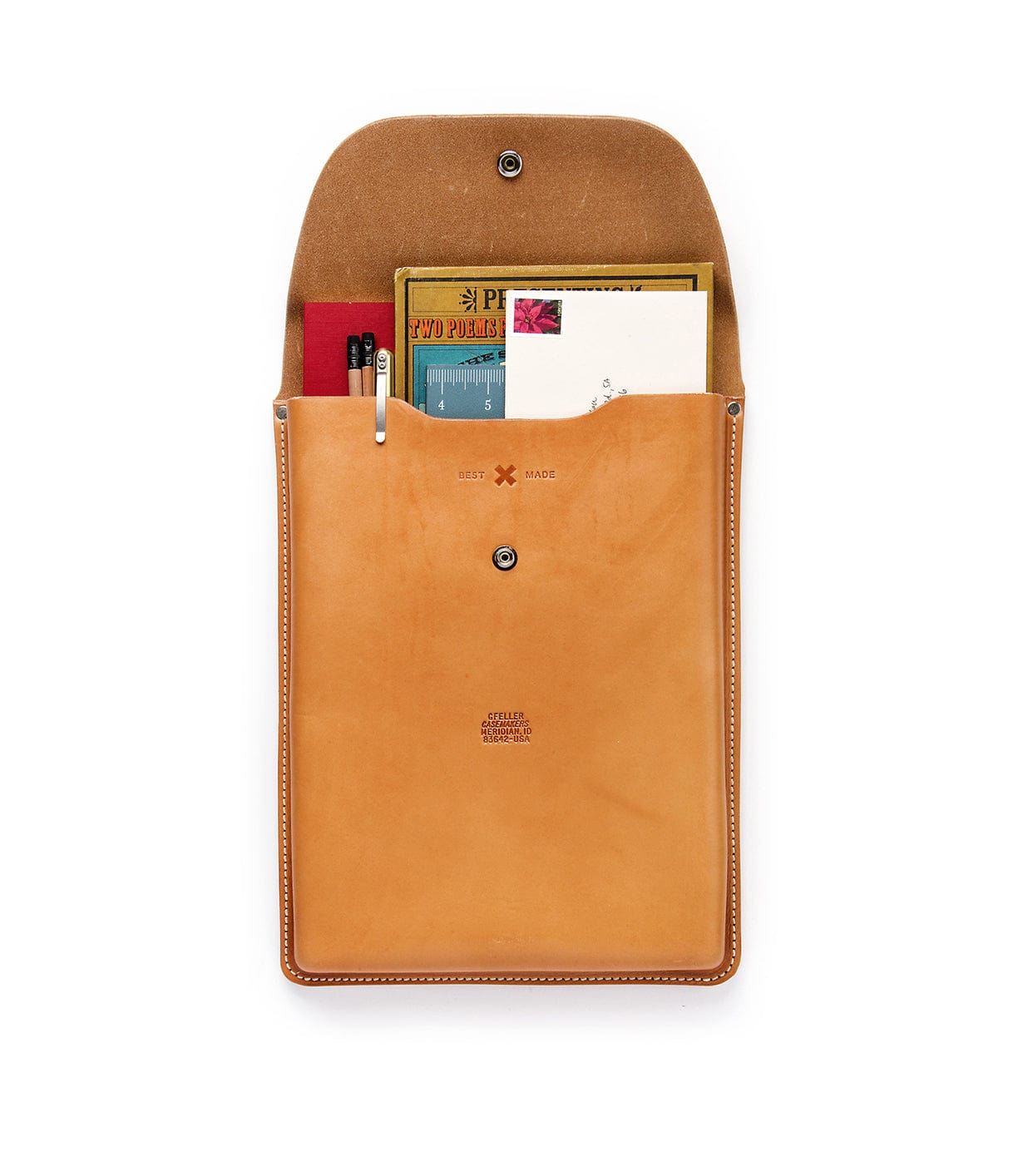 A tan leather pouch with an open flap, containing several items including paper documents, a red notebook, pens, and a small book with an illustrated cover.