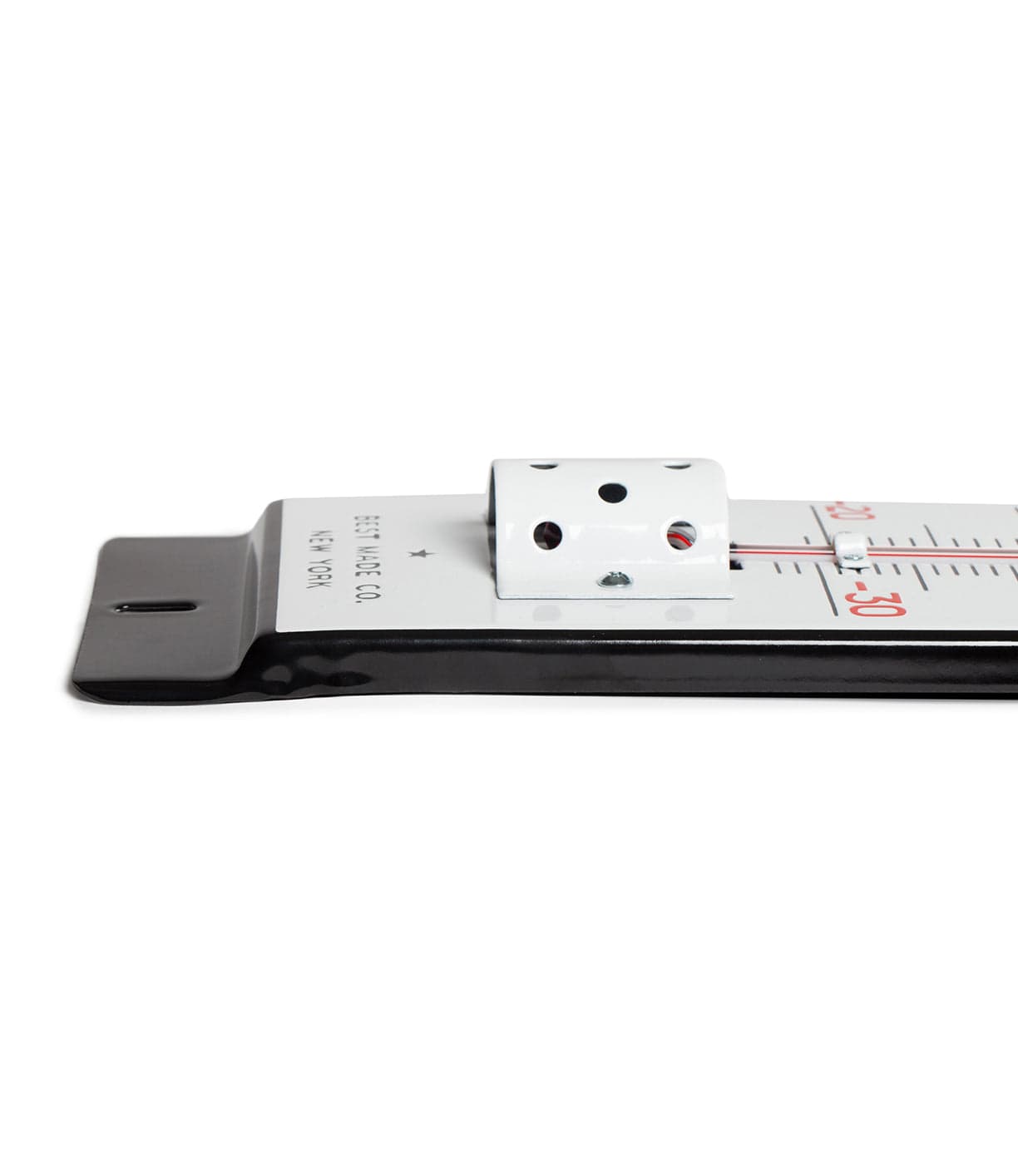 Close-up of a metal measuring tool with a sliding mechanism on a flat surface, displaying a scale in centimeters and inches.