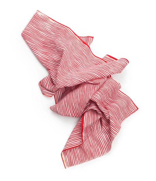 A crumpled red and white striped fabric placed against a plain white background.