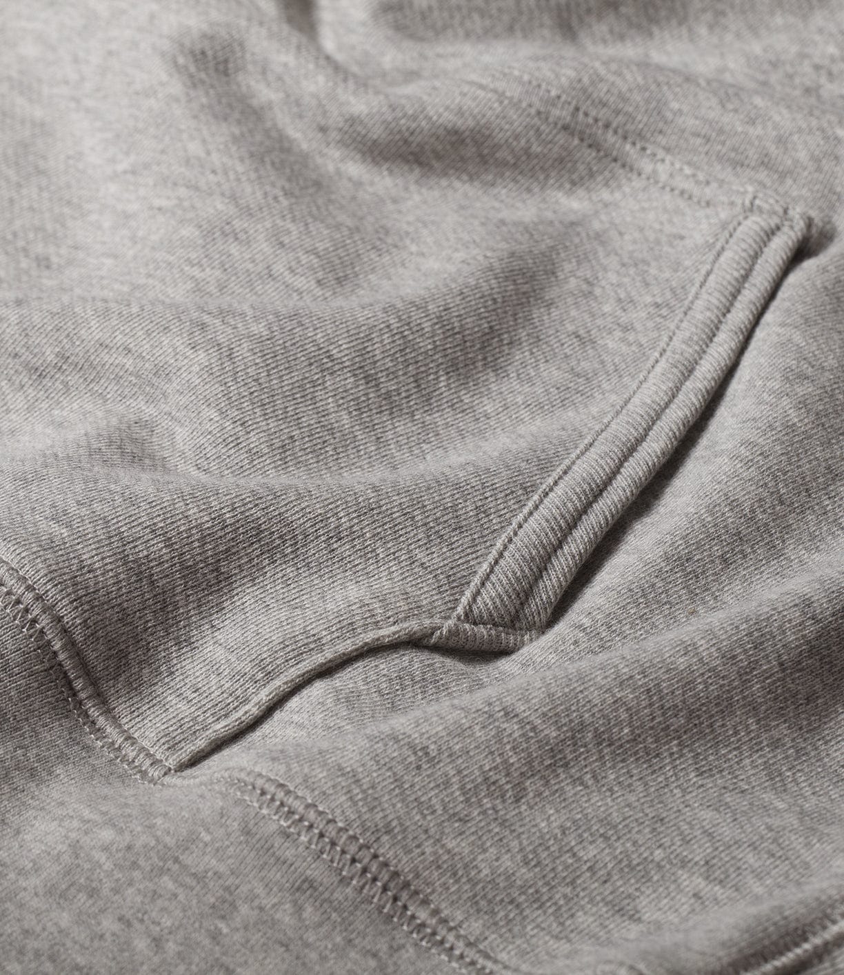 Close-up view of a gray, soft-textured fabric with a visible pocket and seam.