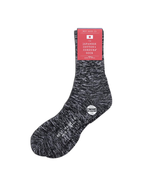 A single gray Japanese cotton cordura sock with white speckling, featuring a red label on top and additional branding near the toe.