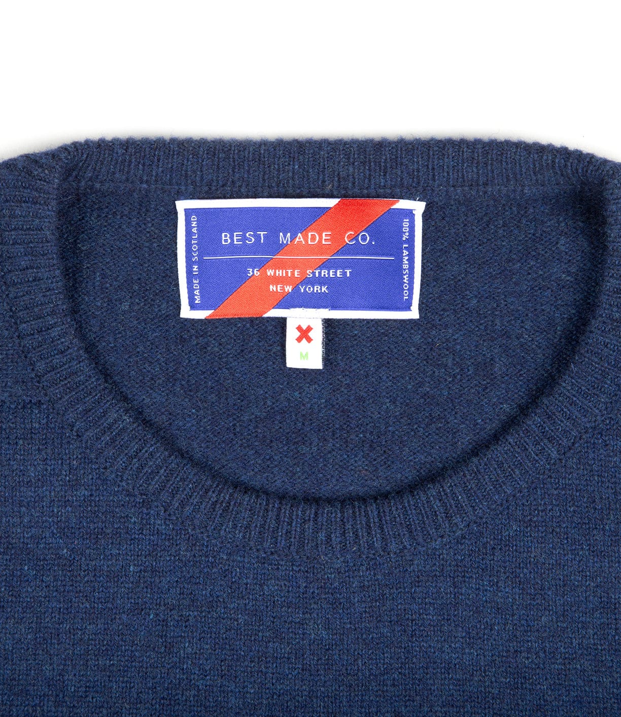 A navy blue sweater with a label reading Best Made Co., 36 White Street, New York, Medium sewn into the inside back collar.