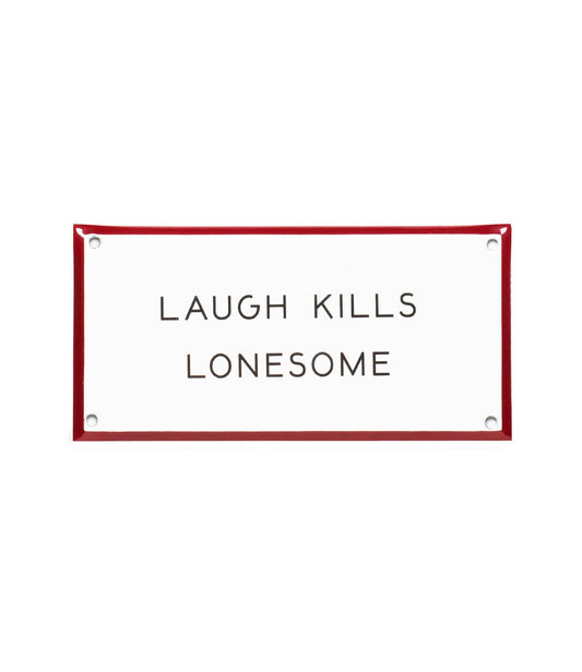 A rectangular sign with a red border and white background reads LAUGH KILLS LONESOME in black uppercase letters.