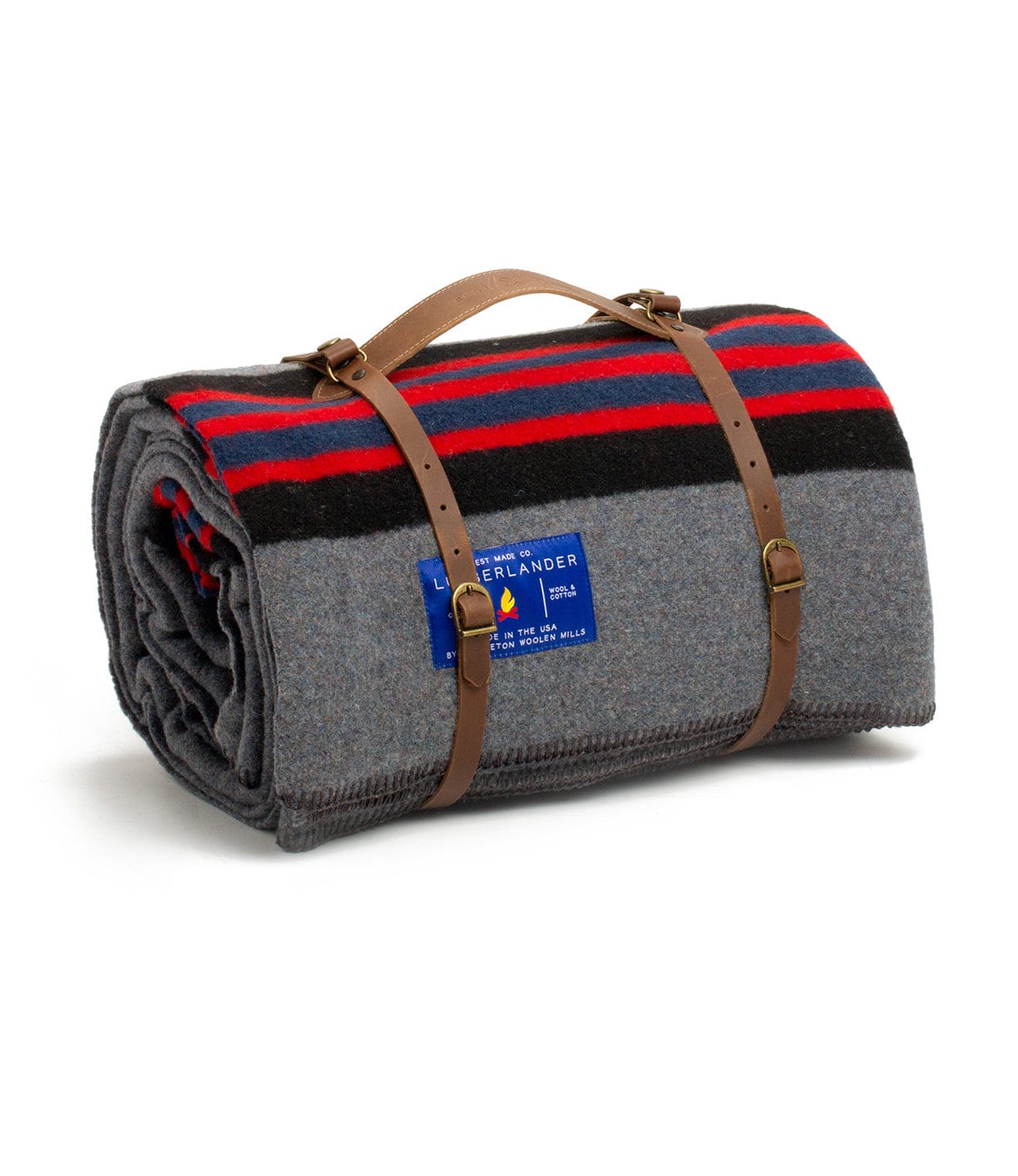 A gray wool blanket with red and black stripes is rolled up and secured with tan leather straps. A blue label is attached to the blanket.