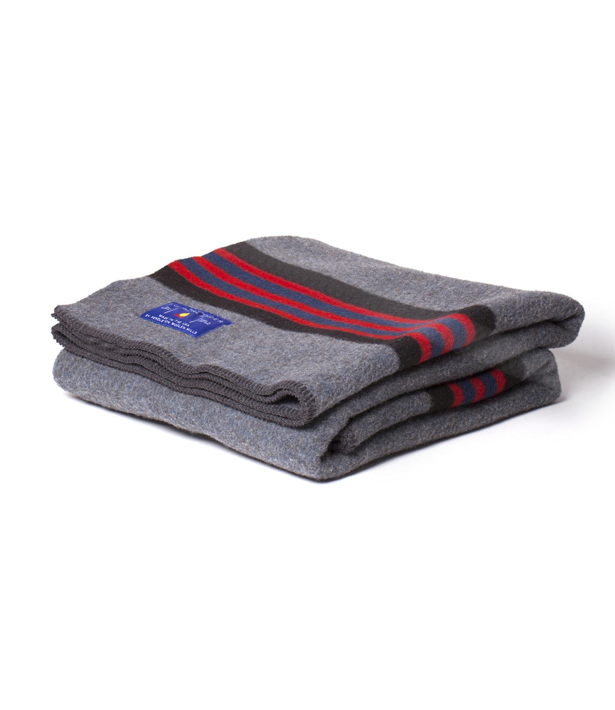 A folded grey blanket with red and black stripes on top, featuring a blue label on one corner.