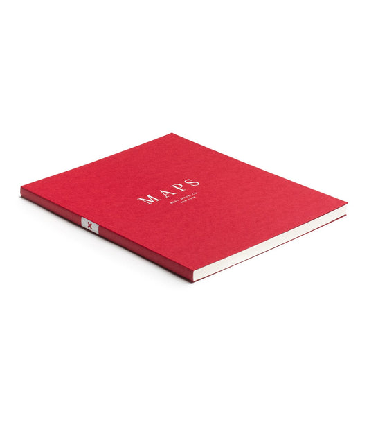 A red book titled MAPS lies closed against a white background. The book is sleek and has a simple, clean cover design with white lettering.