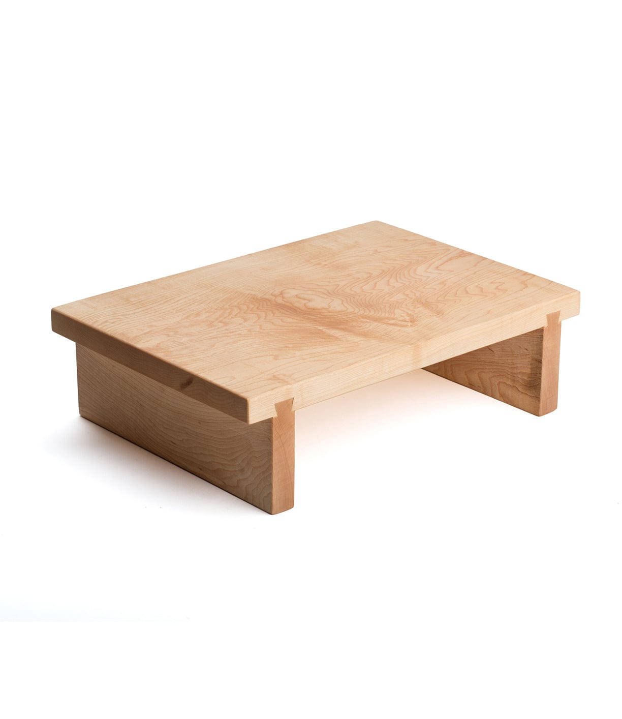 A wooden riser with a natural finish, featuring a flat rectangular top supported by two rectangular legs.