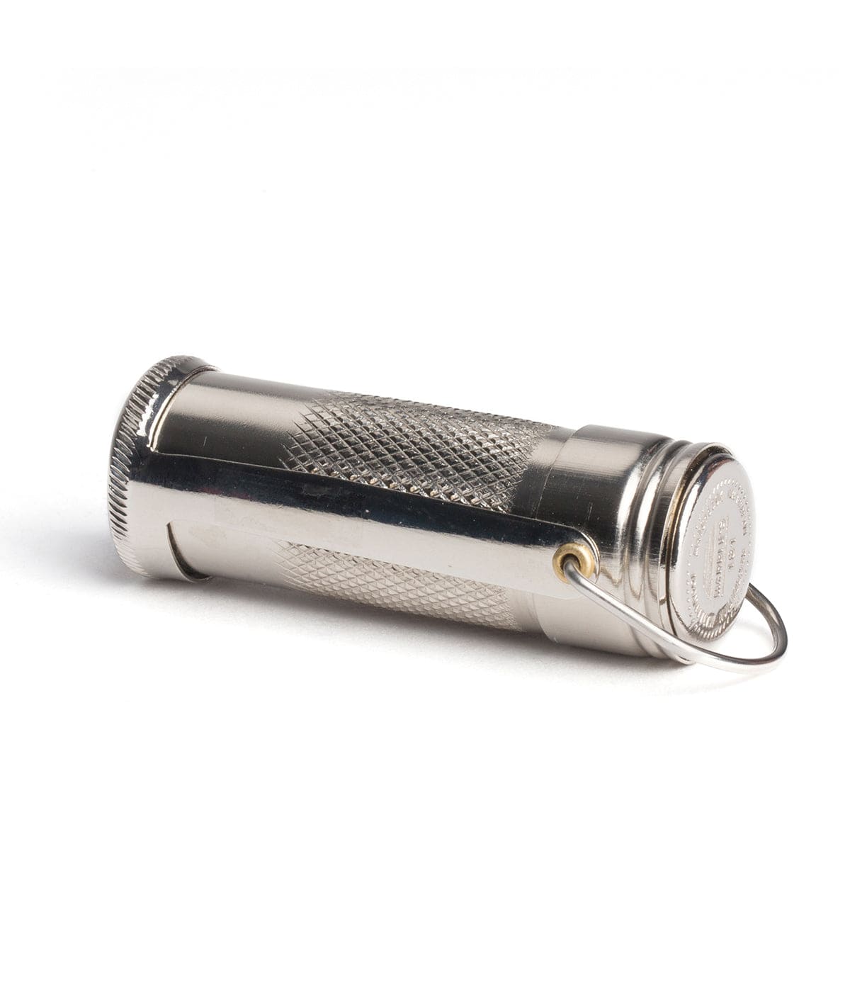 A small, cylindrical metallic container with a textured grip and a keyring attached to one end, lying on a white surface.