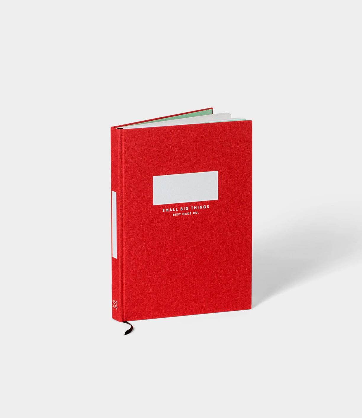 A red hardcover notebook titled Small Big Things, with a black ribbon bookmark, against a white background.