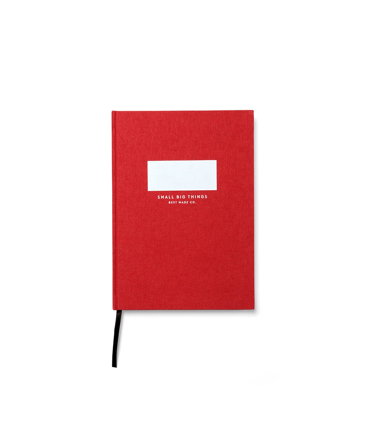 A red hardcover notebook with a white label and Small Big Things Ritz Make Co. written on the cover and a black ribbon bookmark.