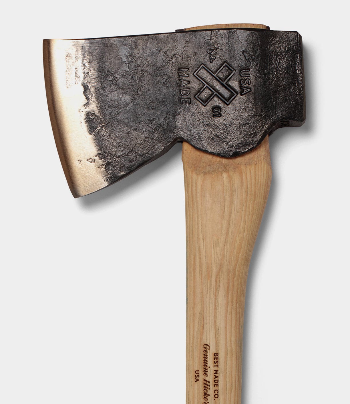 Close-up of a hatchet with a wooden handle and a metal head, engraved with USA MADE and a logo.