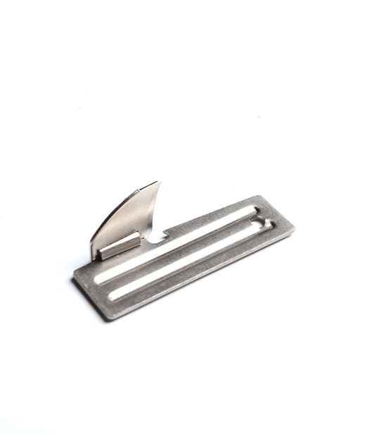 A metal object with a rectangular base featuring two linear cutouts and an upright, curved blade-like component attached.