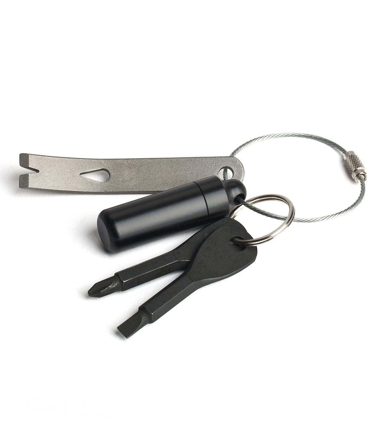 A keychain with two black keys, a small black container, and a metal multi-tool attached to a wire loop.