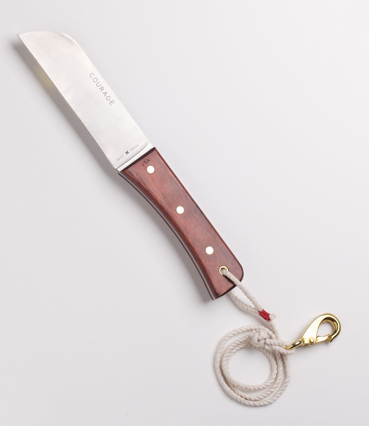 A knife with a wooden handle labeled COURAGE is attached to a white cord with a metal clasp.