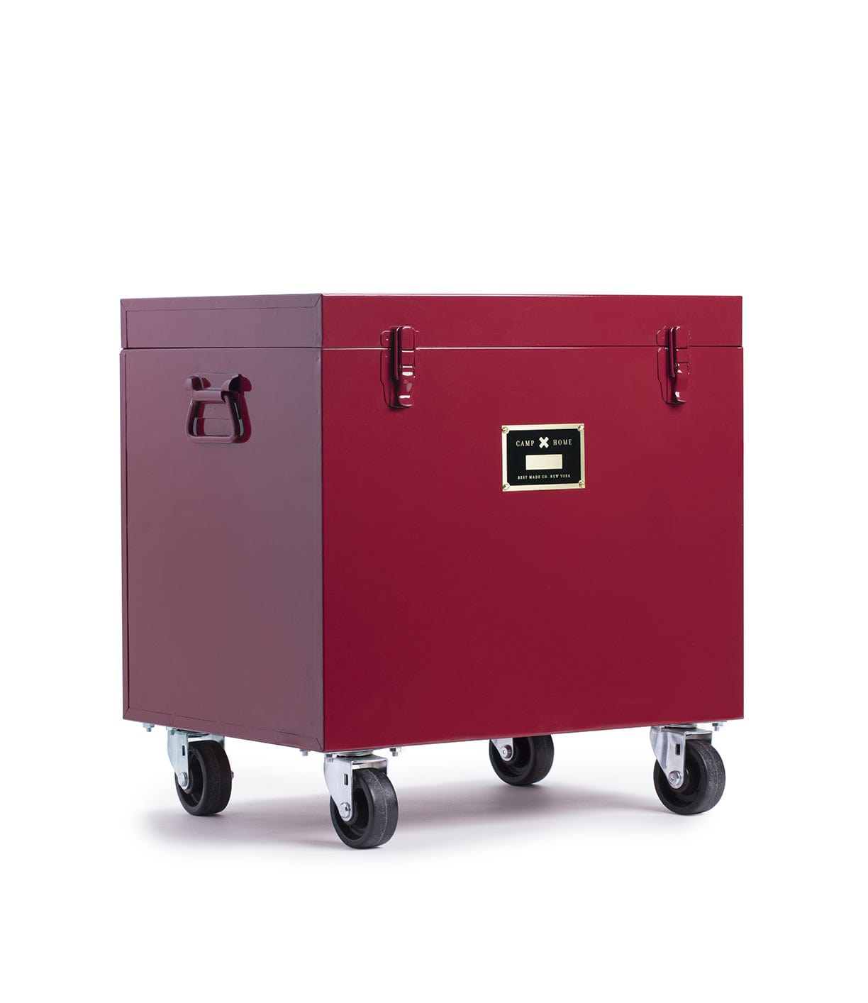 Red box on four caster wheels with side handles and a label on the front.