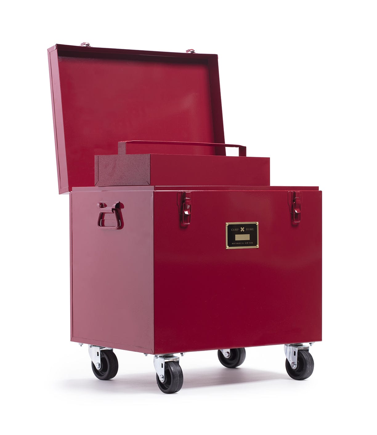 A red metal box on casters with an open lid, revealing a smaller box inside. The larger box has a handle on each side and a label on the front.