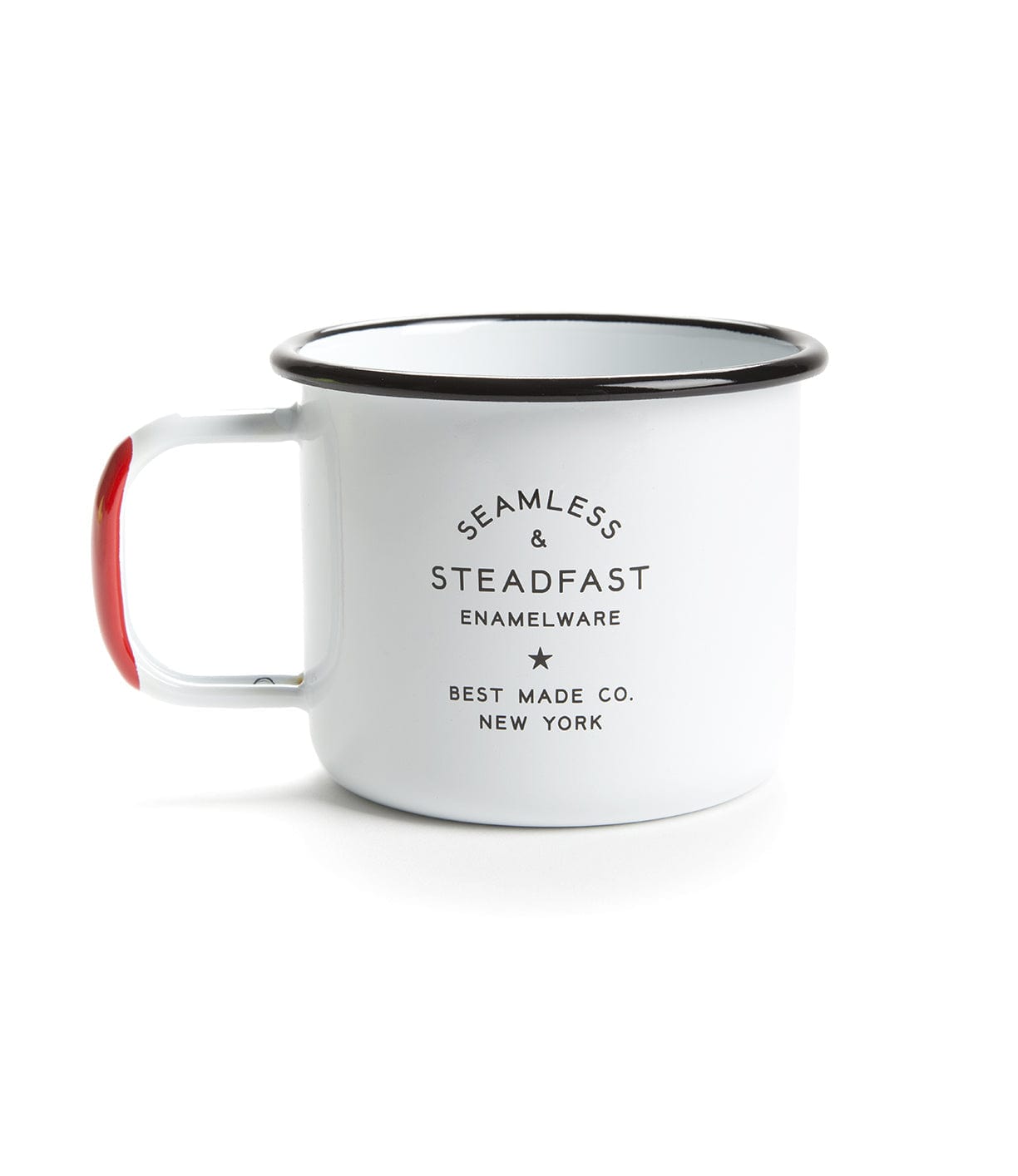 A white enamel mug with a black rim and red accents on the handle. The mug has the text SEAMLESS & STEADFAST ENAMELWARE BEST MADE CO. NEW YORK printed on its side in black.