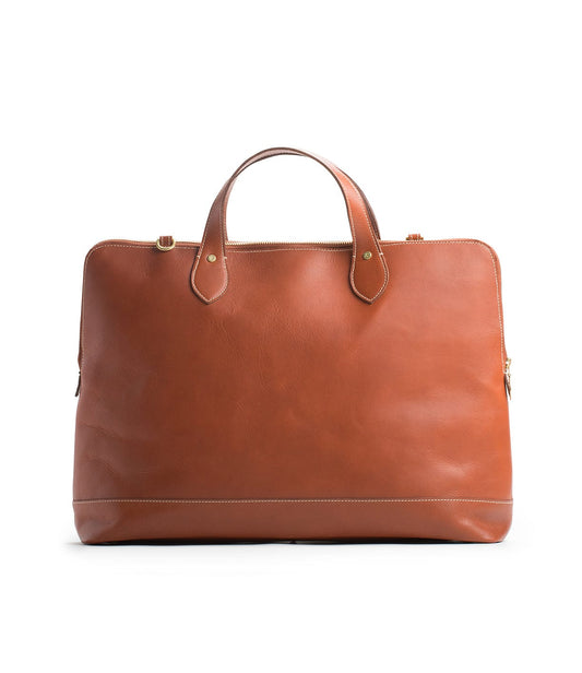 A tan leather briefcase with a simple design, featuring two handles, minimal stitching, and gold-toned hardware, positioned against a plain white background.