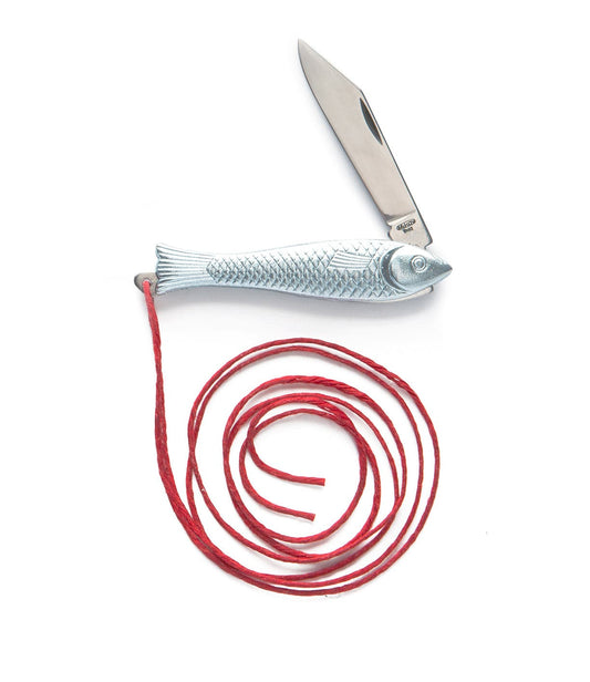 An open knife with a fish-shaped handle lies next to a coiled red string on a white background.