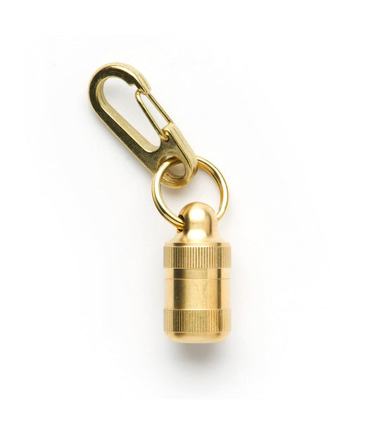 A small gold-colored cylindrical container with a screw top and keychain clip attachment.