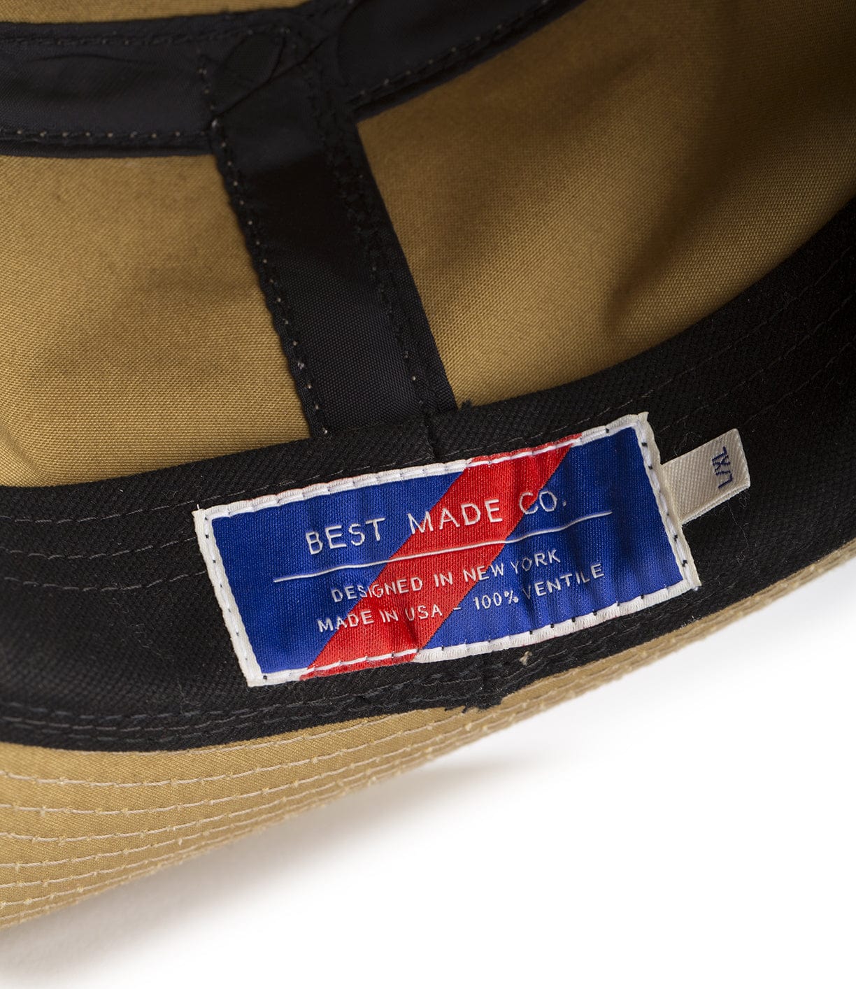 Close-up of a hat's interior displaying a blue label with red stripes that reads Best Made Co. Designed in New York. Made in USA. 100% Gentle.