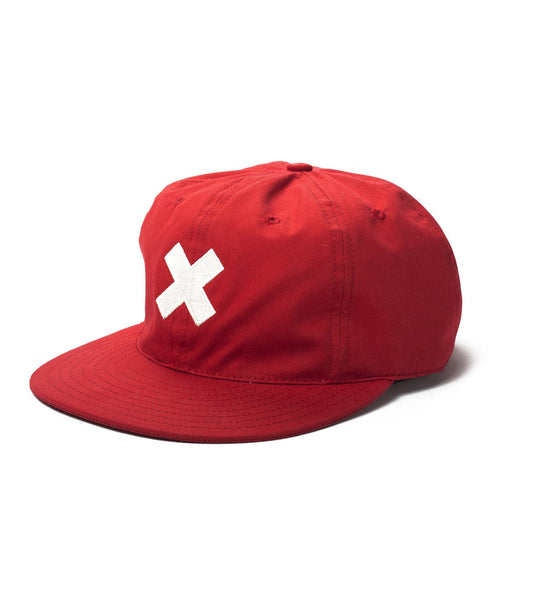 A red baseball cap featuring a large white X on the front.