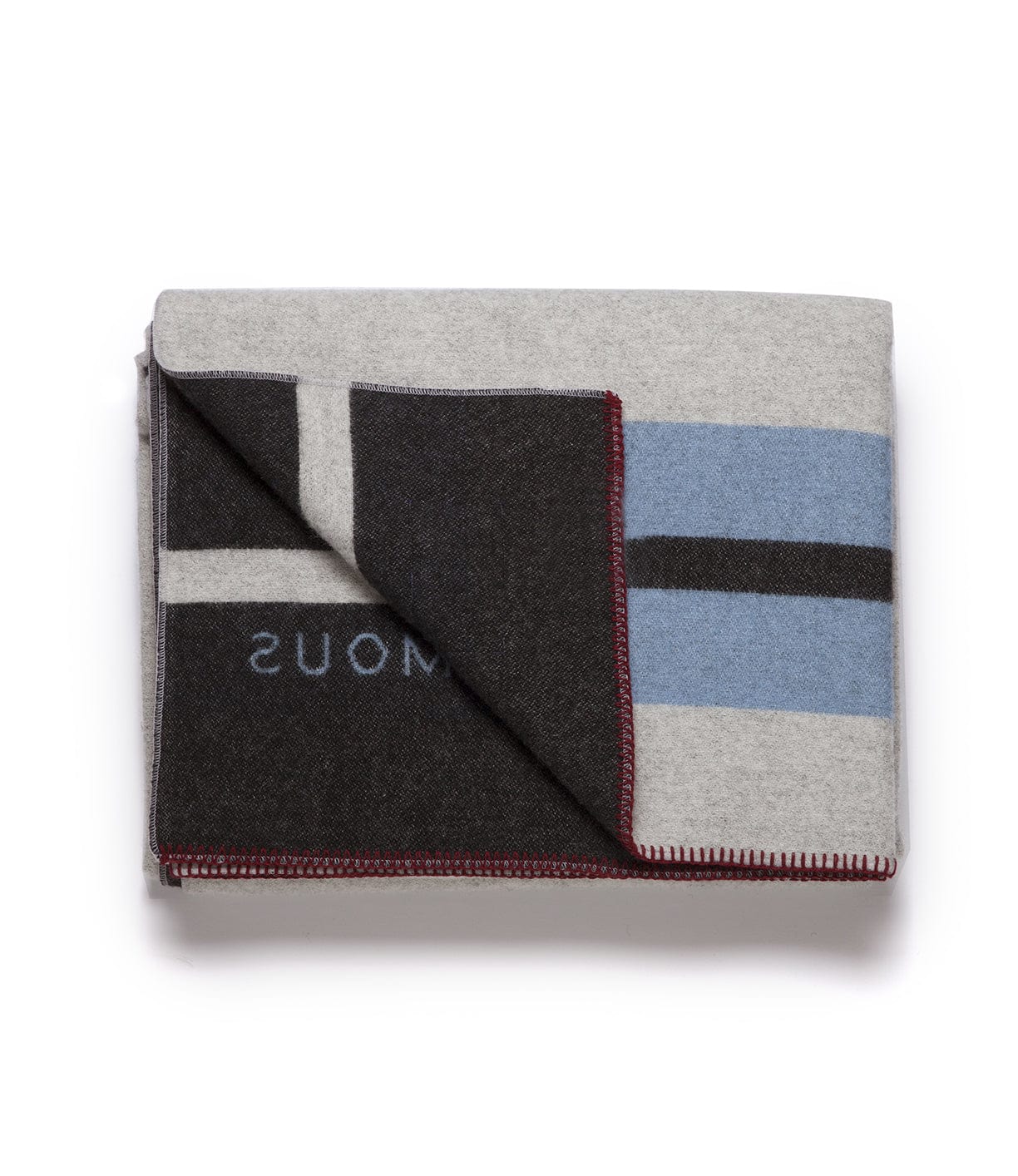 A folded blanket with a grey base, black, blue, and white geometric patterns, and red stitching along the edges.