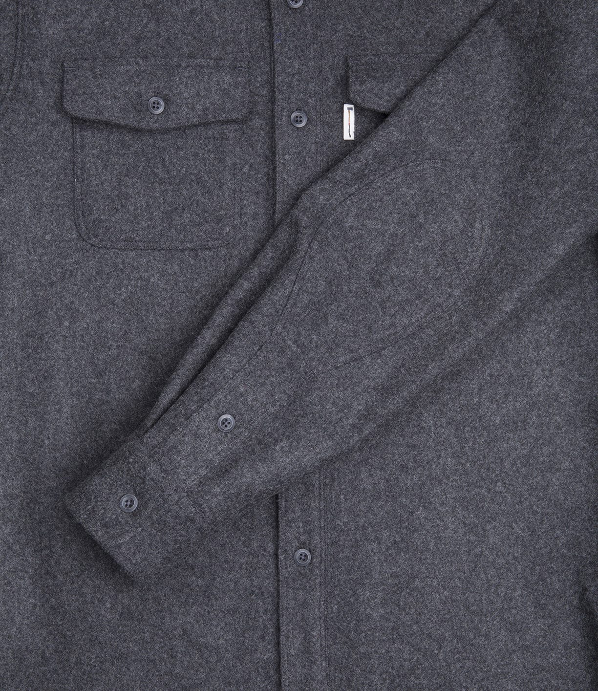 Close-up of a grey button-up shirt with a chest pocket and long sleeves. The fabric appears to be wool or a similar textured material.