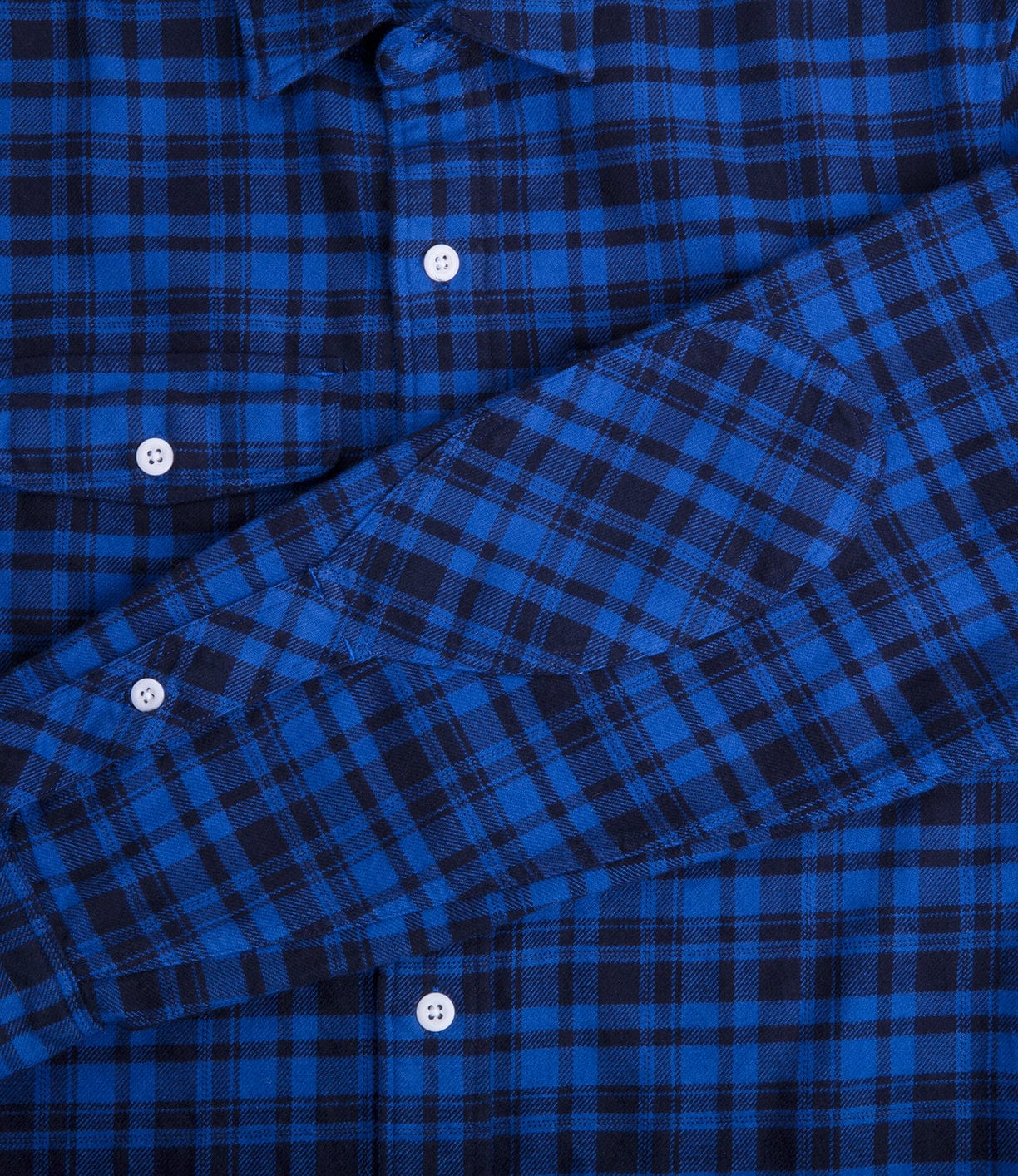 Close-up of a blue and black plaid shirt featuring a chest pocket and white buttons.