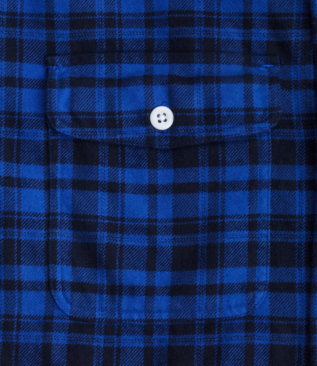 Close-up of a blue and black plaid fabric with a buttoned pocket at the center.